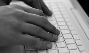 Two hands on a computer keyboard